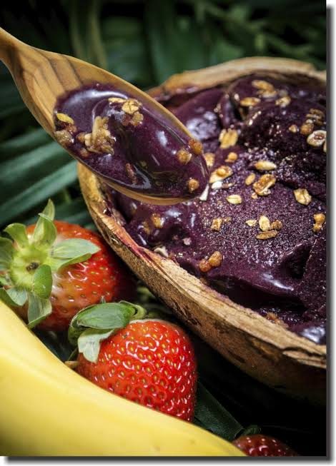 Colher servindo creme de açaí com morango e banana